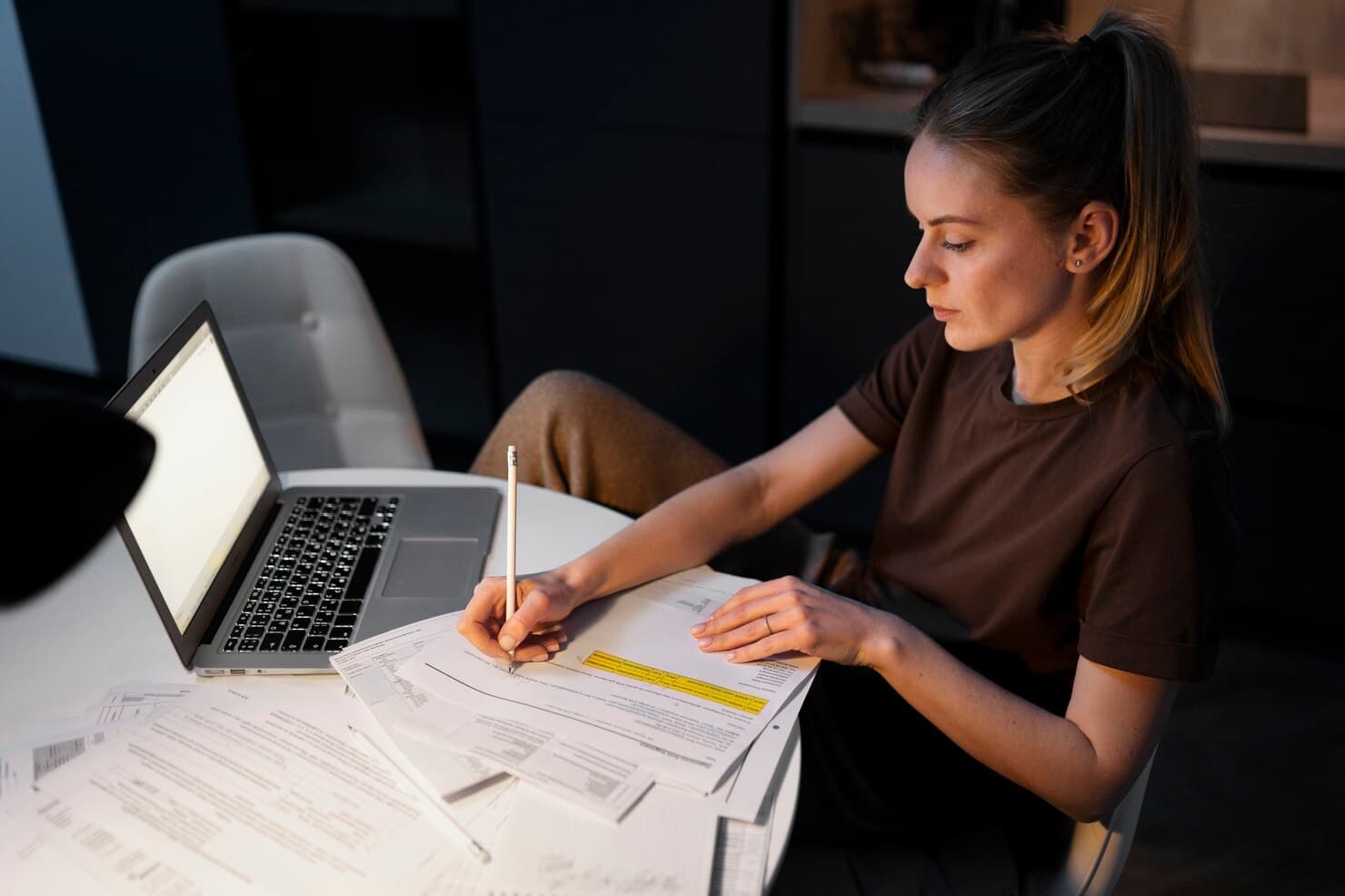 Person surrounded by paperwork with Less manual data entry text overlay